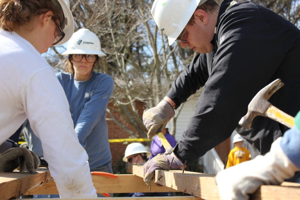 A photo of teens working on a Habitat for Humanity housing project