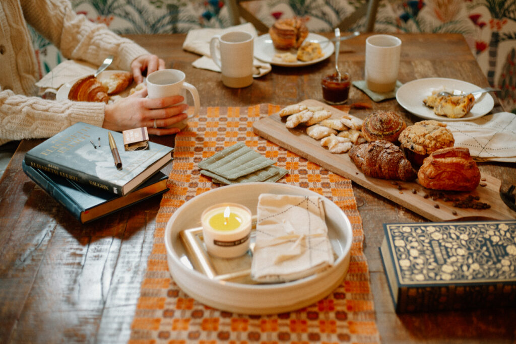 Two women sitting around a table, surrounding by locally purchased goods